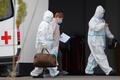 Medical specialists accompany a woman outside a hospital for patients infected with coronavirus disease in Moscow