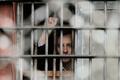 A Belarussian detainee, arrested during the flash mob "Revolution through a social network", gestures from a prison cell at a detention centre in Minsk