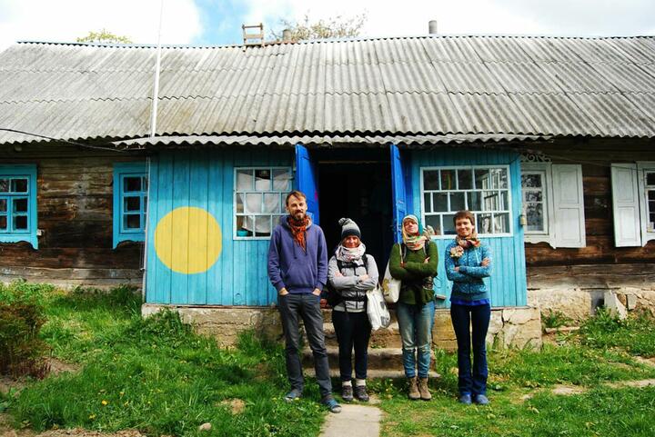 Верасень і Аўгіння з замежнымі гасцямі насупраць сваeй хаты. Фота: downshifter.by