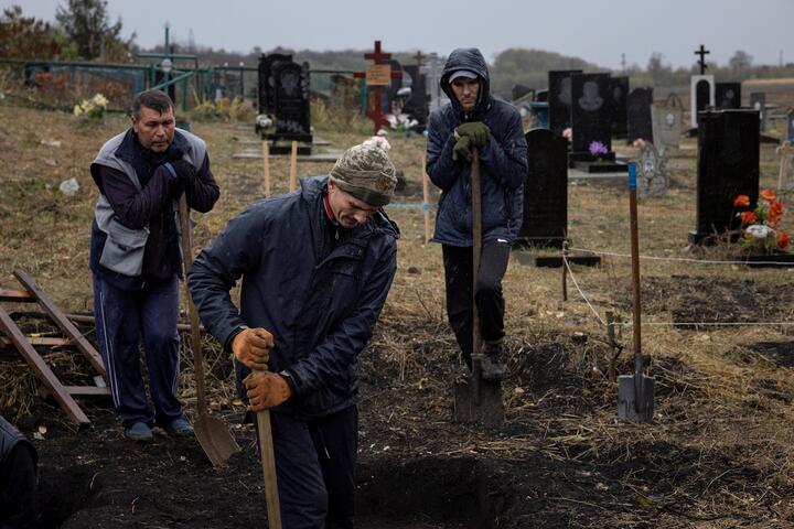 Местные жители роют могилы на кладбище в селе Гроза под Харьковом, Украина, 9 октября 2023 года. Фото: Reuters